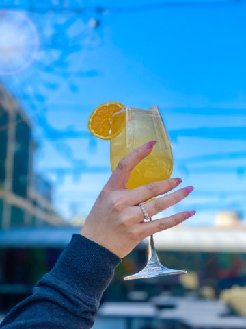 woman's hand lifting a cocktail into the air